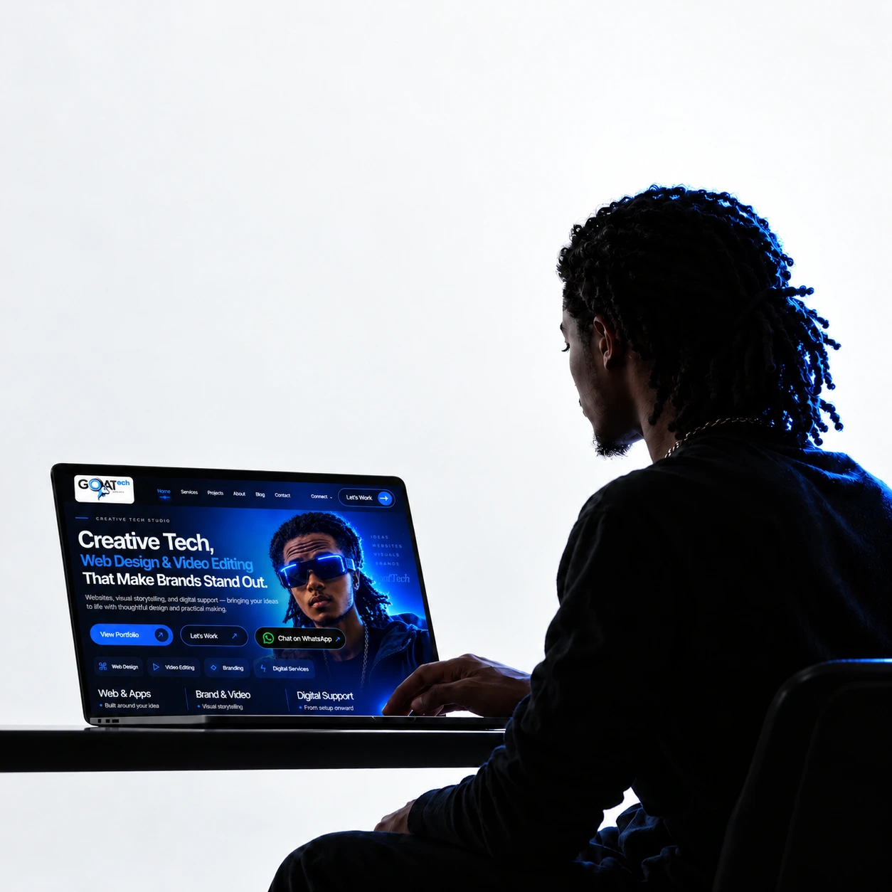 The supplied GoatTech portrait of a person working at a laptop
